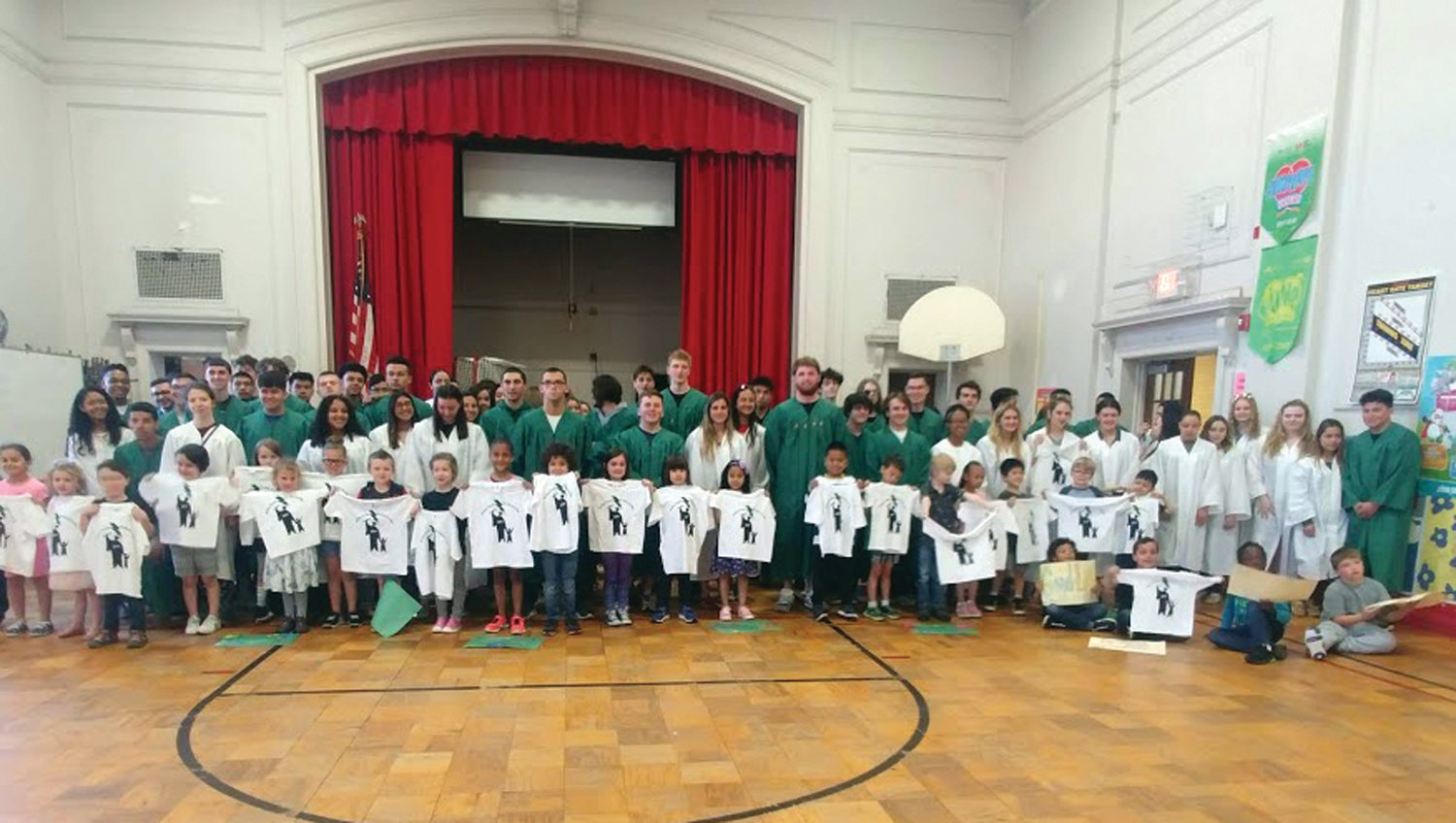 RETURN TO RHODES: The seniors handed out their T-shirt gifts to the kindergarten students and posed for a group photo. The kindergarten students will graduate in 2031.